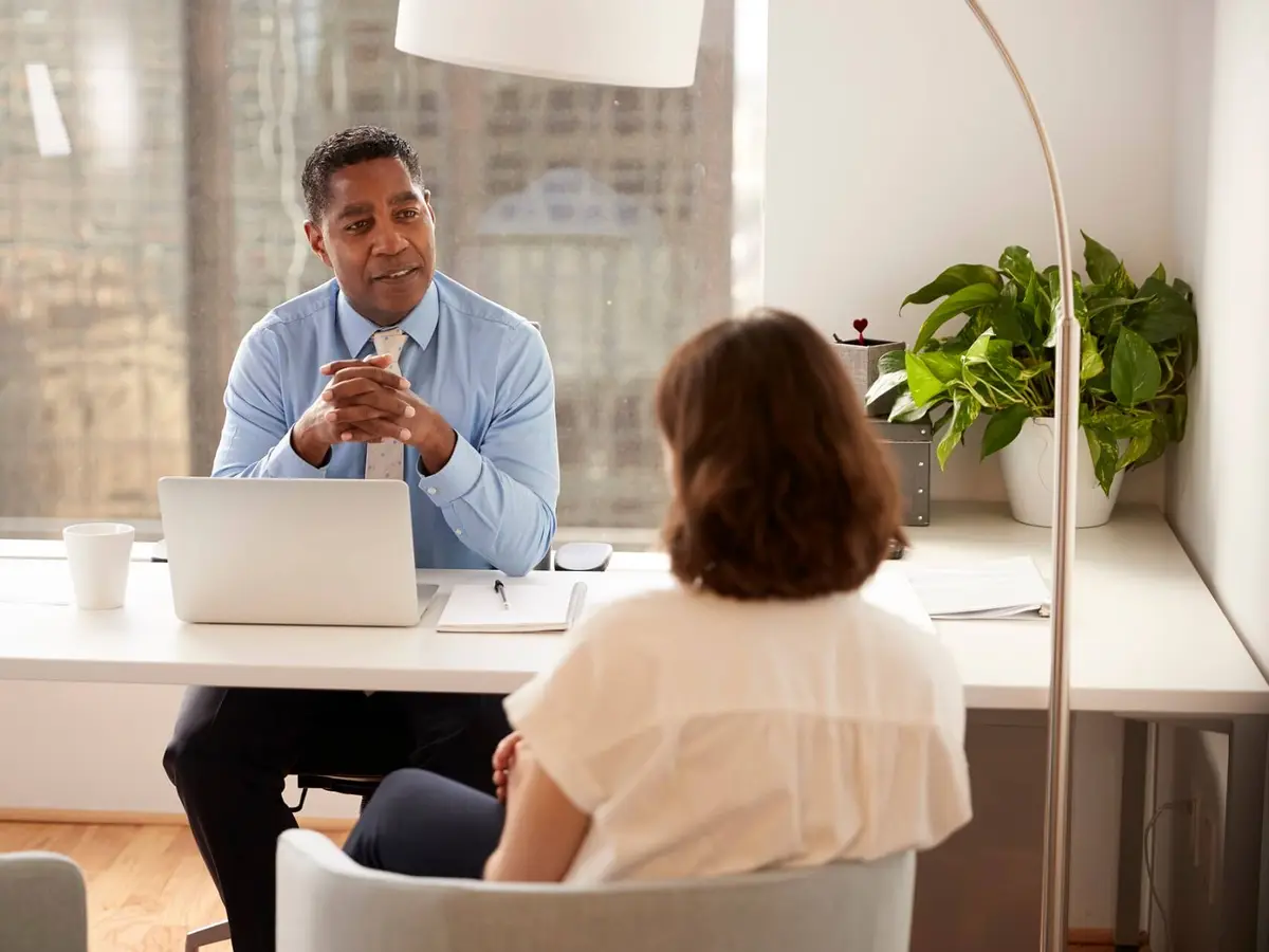 An advisor meeting a client in a modern glass office